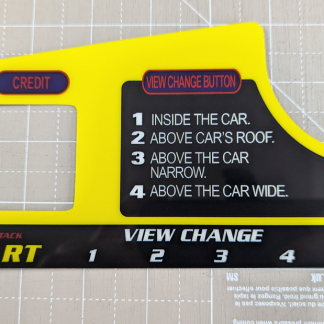 A reproduction dash instructions decal for Daytona USA 2 arcade cabinets. UK/Euro version with a credit button on the dashboard. Direct reverse printed to 0.375mm gloss polycarbonate with a 3m adhesive backing, then CNC cut to shape.